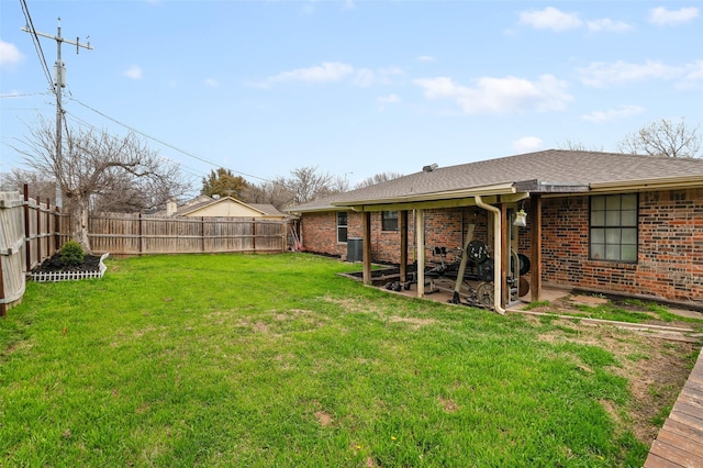 view of yard with central AC unit, a fenced backyard, and a patio area