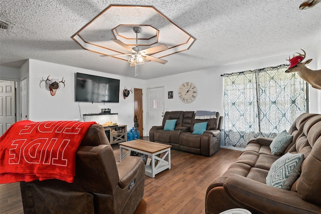 living room with a textured ceiling, wood finished floors, and a ceiling fan