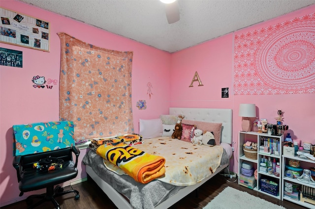 bedroom with ceiling fan, wood finished floors, and a textured ceiling