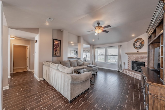 living room with visible vents, baseboards, a brick fireplace, wood tiled floor, and vaulted ceiling