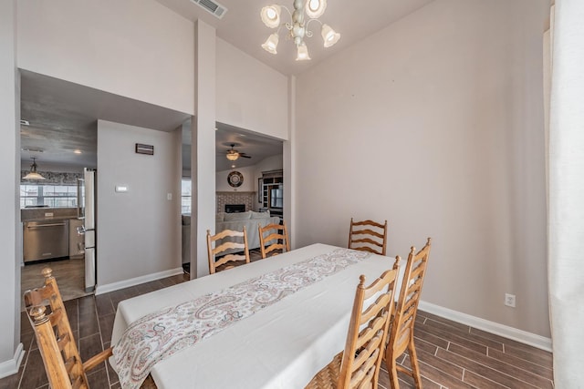 dining space featuring visible vents, a fireplace, baseboards, and wood finish floors