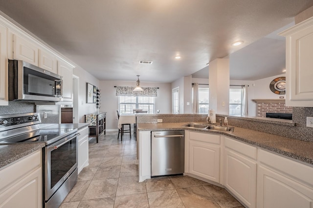 kitchen featuring visible vents, backsplash, appliances with stainless steel finishes, white cabinetry, and a sink