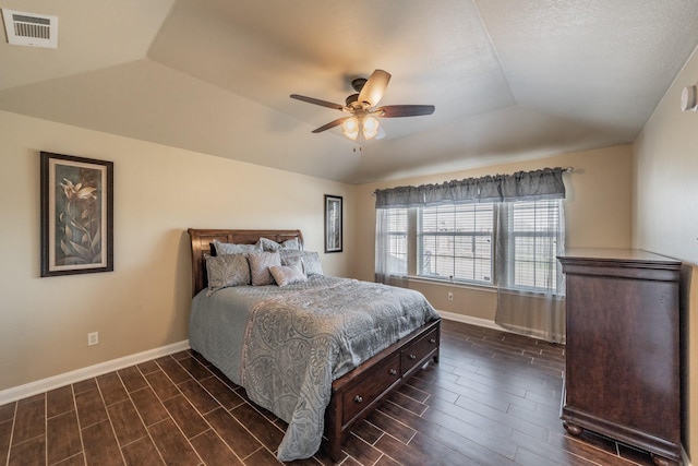 bedroom featuring a tray ceiling, baseboards, visible vents, and wood tiled floor