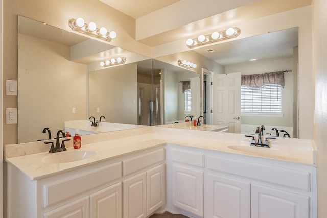 full bathroom featuring double vanity and a sink