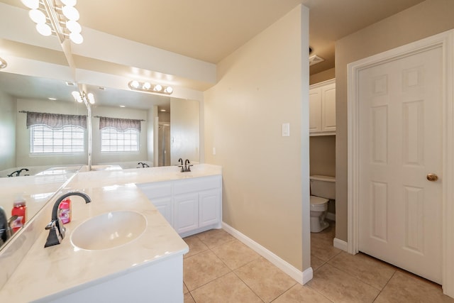 full bath with a sink, toilet, double vanity, and tile patterned flooring