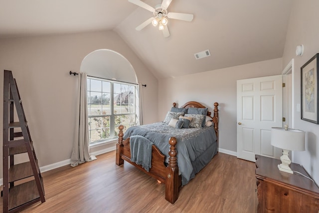 bedroom with visible vents, baseboards, lofted ceiling, and wood finished floors