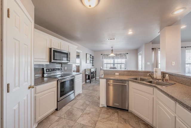 kitchen featuring visible vents, a sink, tasteful backsplash, appliances with stainless steel finishes, and white cabinets