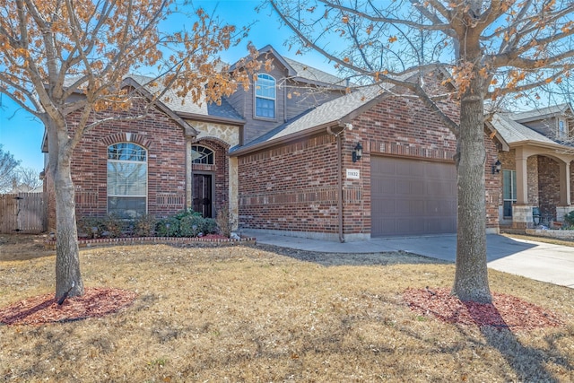 view of front of property featuring driveway, roof with shingles, a front yard, a garage, and brick siding