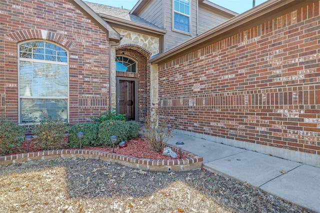 view of exterior entry with brick siding