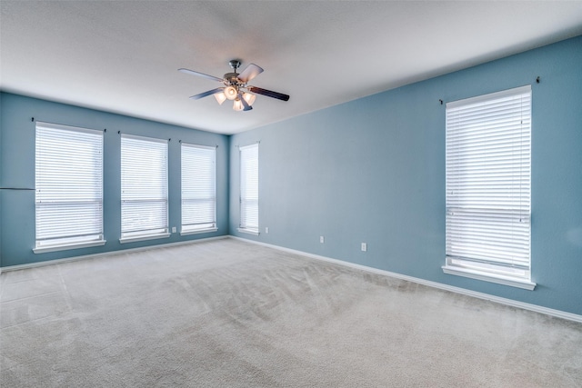 unfurnished room with baseboards, ceiling fan, and carpet floors