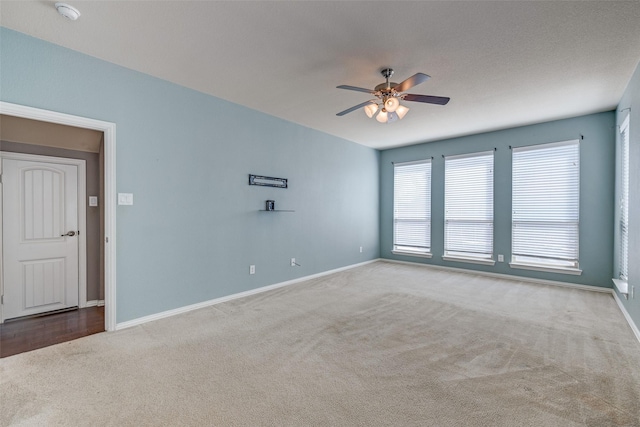 unfurnished room with baseboards, ceiling fan, and carpet flooring