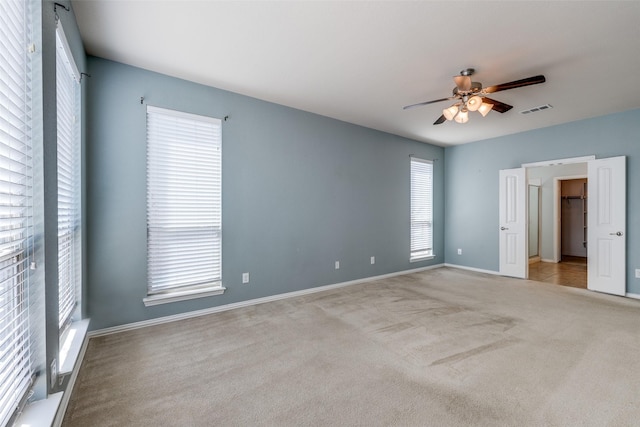 unfurnished bedroom featuring carpet flooring, a ceiling fan, visible vents, and baseboards