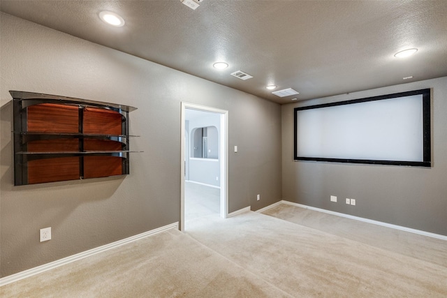 cinema room with visible vents, baseboards, carpet, recessed lighting, and a textured ceiling