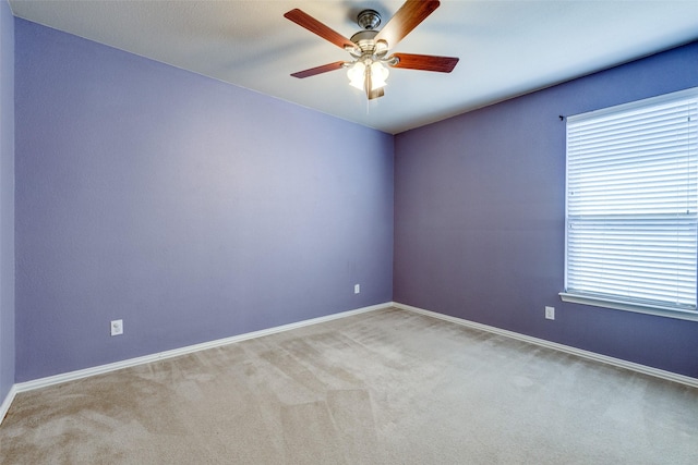 empty room featuring carpet flooring, a healthy amount of sunlight, baseboards, and ceiling fan