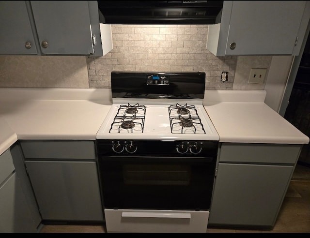 kitchen featuring gray cabinetry, ventilation hood, and range with gas cooktop