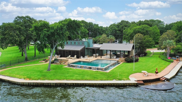 back of property featuring a water view, a standing seam roof, a fenced backyard, a yard, and metal roof