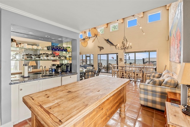 kitchen featuring a sink, plenty of natural light, white cabinets, and crown molding