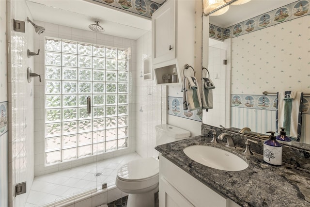 bathroom with a shower stall, wallpapered walls, toilet, and vanity