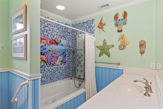 full bath featuring a tub with jets, visible vents, a sink, wainscoting, and crown molding