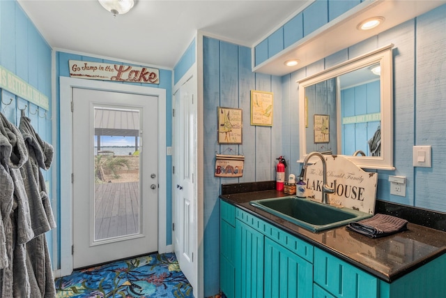 interior space with dark countertops, blue cabinetry, and a sink