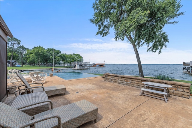 view of swimming pool with a patio and a water view