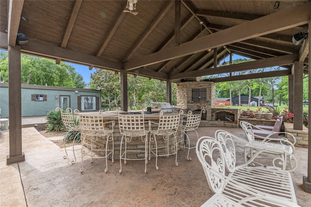 view of patio / terrace featuring a gazebo, an outdoor stone fireplace, and outdoor dry bar