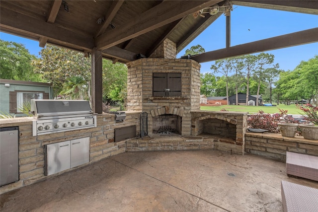 view of patio / terrace featuring area for grilling, grilling area, and an outdoor stone fireplace