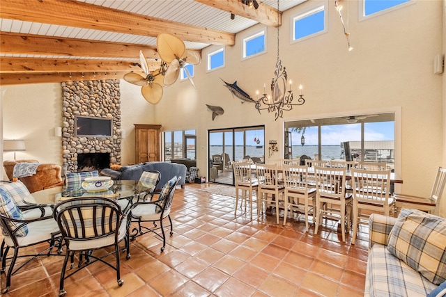 dining room featuring beam ceiling, plenty of natural light, a fireplace, and light tile patterned floors