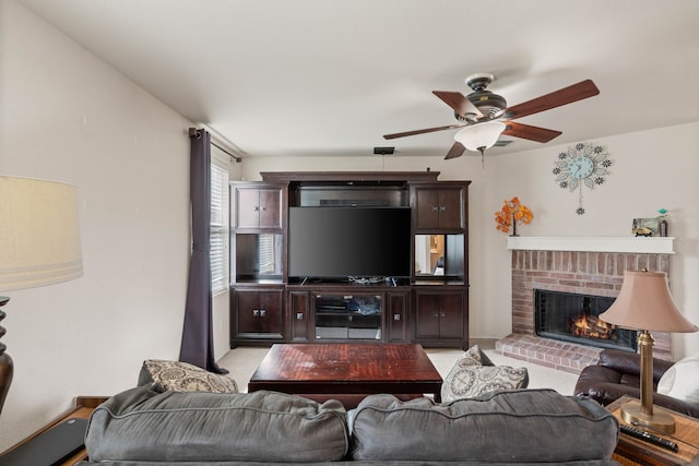 living area featuring a brick fireplace and a ceiling fan