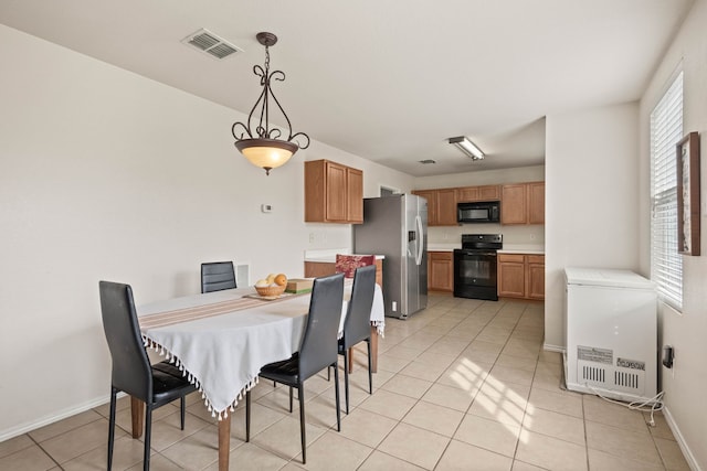 dining room featuring light tile patterned floors, visible vents, and baseboards