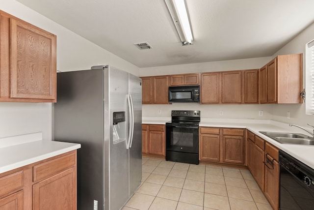 kitchen featuring visible vents, light countertops, light tile patterned flooring, black appliances, and a sink