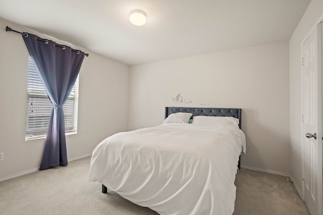 bedroom featuring light colored carpet and baseboards