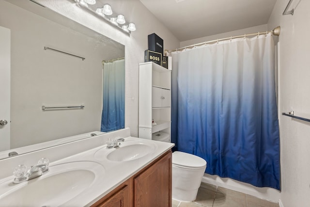 bathroom featuring tile patterned floors, toilet, double vanity, and a sink