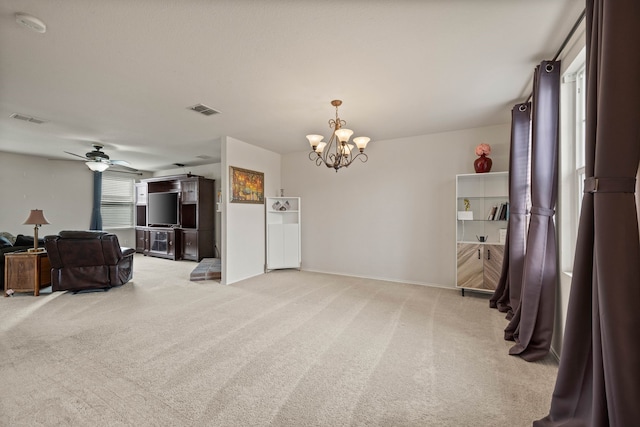 interior space with visible vents, light carpet, and ceiling fan with notable chandelier