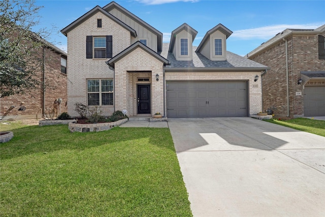 view of front of property with driveway, a front yard, brick siding, and an attached garage