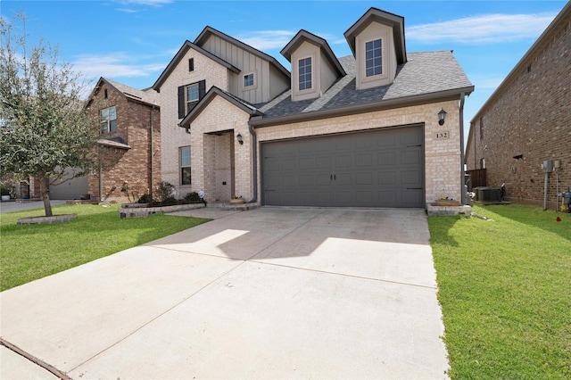 view of front of property featuring a front yard, concrete driveway, central AC unit, and a garage