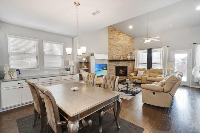 dining space featuring dark wood-style floors, visible vents, plenty of natural light, and a stone fireplace