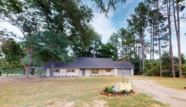 ranch-style house featuring a front yard, an attached garage, and driveway