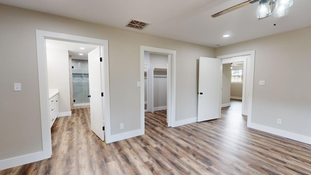 bedroom with visible vents, baseboards, and wood finished floors