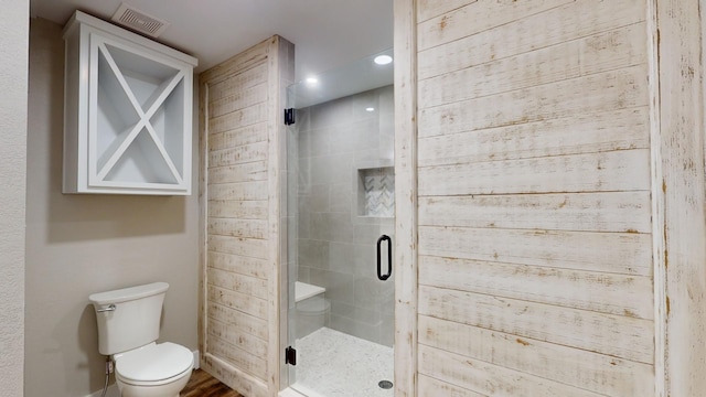 full bathroom featuring visible vents, toilet, and a shower stall