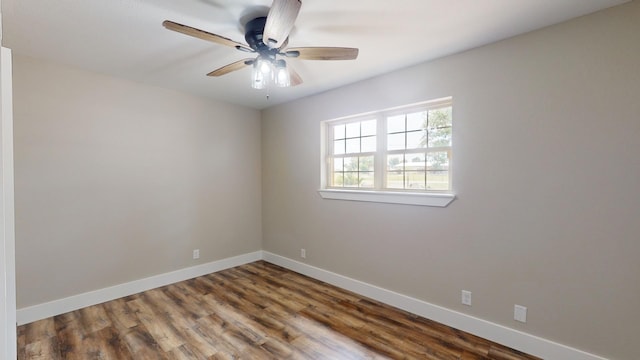 empty room featuring a ceiling fan, baseboards, and wood finished floors