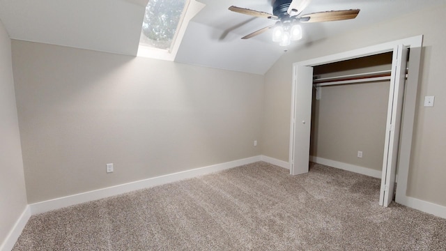 unfurnished bedroom featuring a closet, carpet, baseboards, ceiling fan, and vaulted ceiling