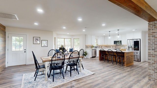 dining room with recessed lighting, visible vents, a wealth of natural light, and light wood-type flooring