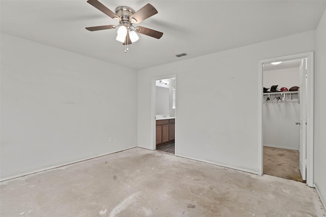 unfurnished bedroom featuring visible vents, unfinished concrete floors, a walk in closet, ensuite bathroom, and a closet