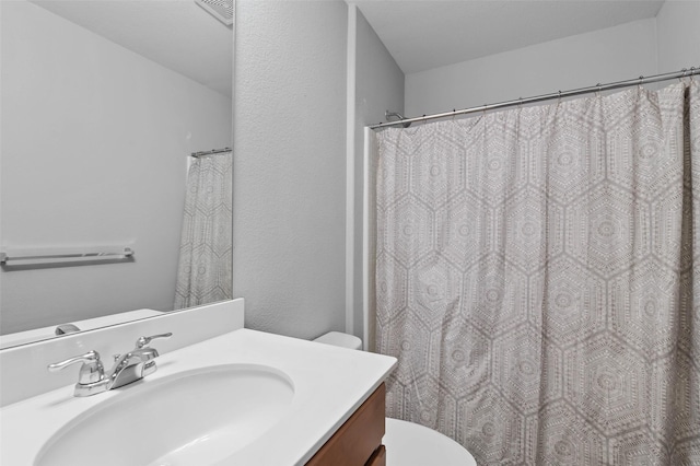 bathroom with visible vents, toilet, and vanity