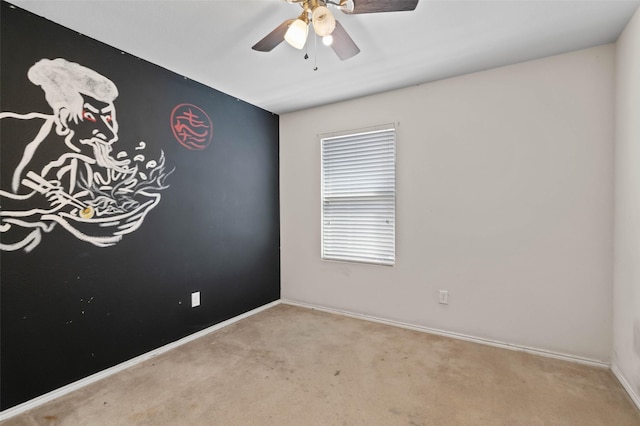 carpeted spare room featuring baseboards and ceiling fan