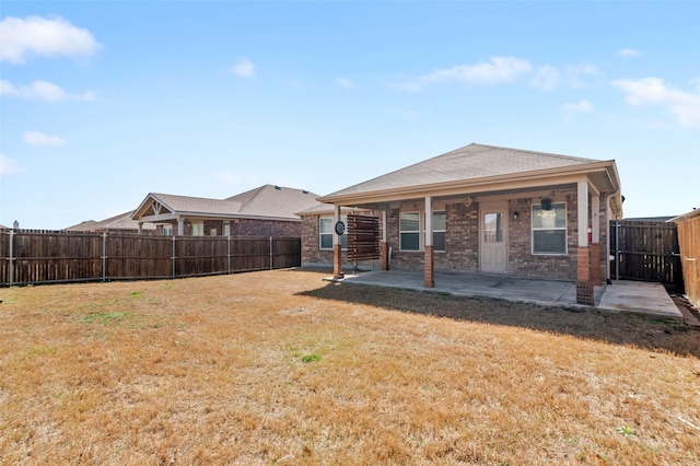 rear view of house featuring brick siding, a lawn, a patio, and a fenced backyard