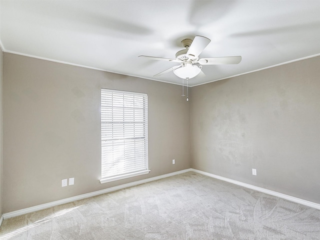 carpeted spare room featuring baseboards and ceiling fan