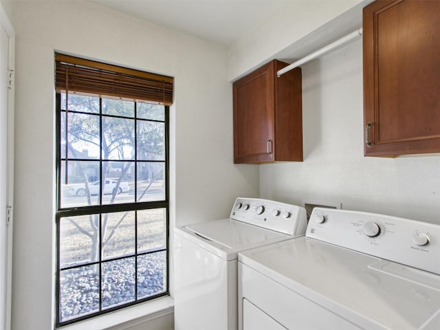 laundry room with separate washer and dryer and cabinet space