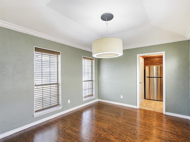 unfurnished room featuring ornamental molding, lofted ceiling, baseboards, and wood finished floors